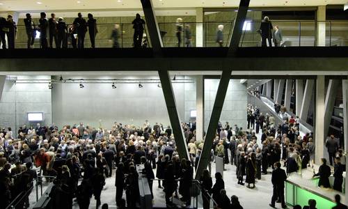 Foyer 1.05 und 3.11 Im gesamten Foyer 1.05 und in der Ebene darüber, dem Foyer 3.11, befinden sich sehr viele Menschen im Rahmen einer Veranstaltung.