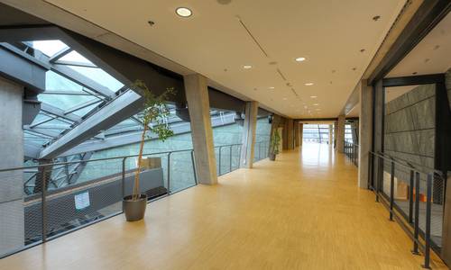 Foyer 3.11 Blick durch das Foyer 3.11 vom Aufzug hin bis zu den Fenstern in der Alexanderstraße. Im Foyer befindet sich kein Mobilar- sichtbar sind nur die Betonpfeiler und das Geländer, die das gesamte Foyer säumen. Man erkennt die Außenwand des Saals spectrum auf der rechten Seite. Auf der linken Seite befinden sich das obere Ende der Calla.
