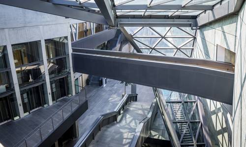 Urheber Fotografie Schepp Blick vom Foyer 3.11 über die Haupttreppe hinunter zum Haupteingang. Hinter der Brücke, die die Konferenzebene mit dem Raum ferrum verbindet, erkennt man die calla.